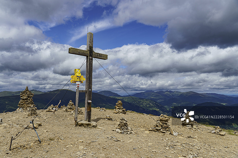 山峰上的十字架和石堆,云雾缭绕,视野开阔,地点:奥地利卡恩顿州巴德克莱因基希姆阿尔卑斯山。图片素材