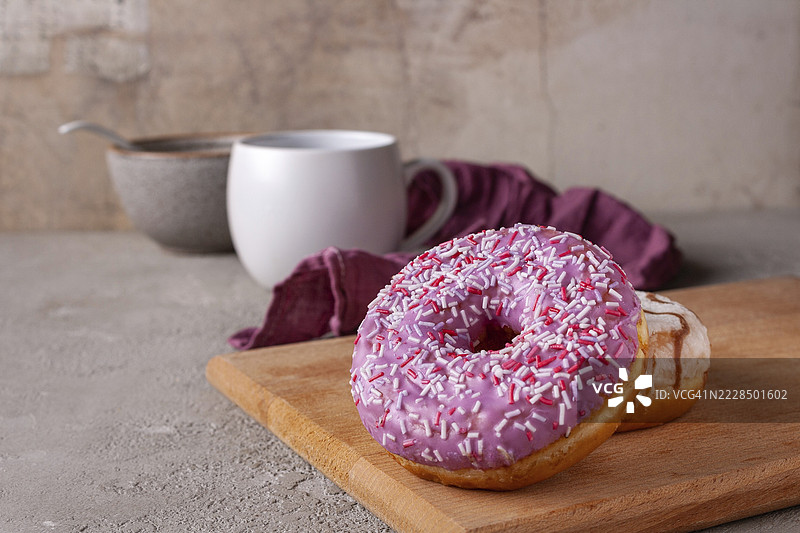 粉色和白色的甜甜圈放在木板上，留有文字空间图片素材