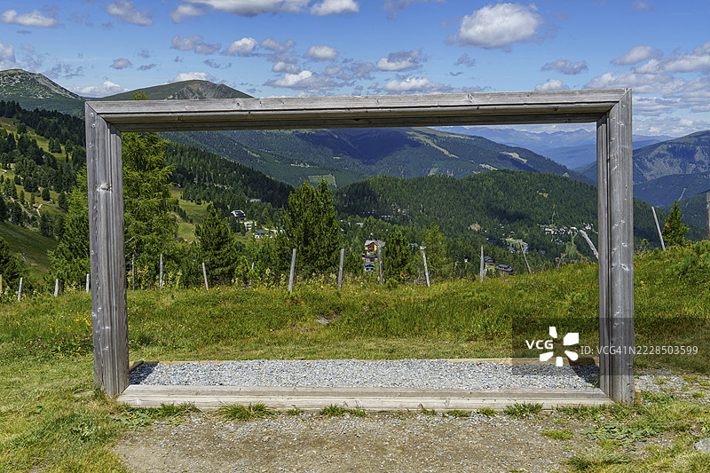 一个木框架勾勒出卡林西亚州奥地利巴德克莱因基希海姆的广阔山景。图片素材