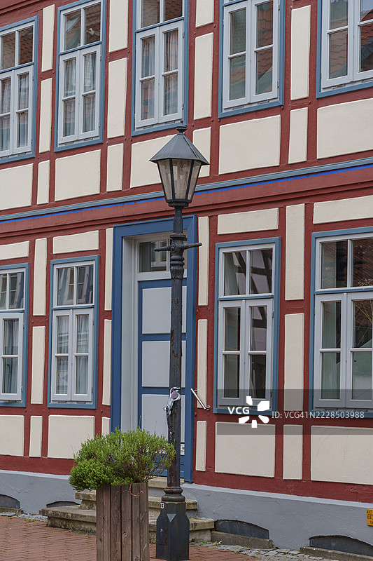 时尚的半木结构房屋细节，蓝色门和灯笼，德国下萨克森州希尔德斯海姆图片素材