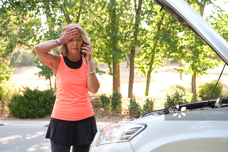 老年运动员呼叫援助，因汽车故障需要帮助图片素材
