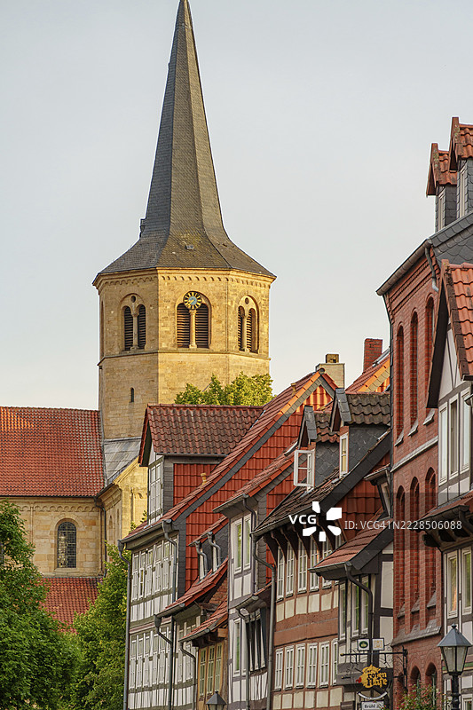 教堂塔楼高耸于下萨克森州希尔德斯海姆历史悠久的老城区的半木结构房屋之上图片素材