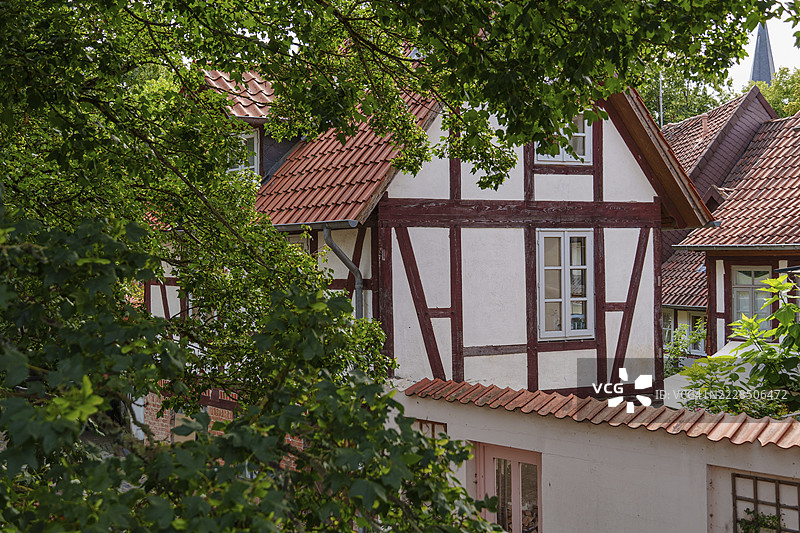 德国下萨克森州希尔德斯海姆的传统半木结构房屋，红色瓦屋顶和绿色叶子。图片素材