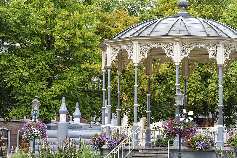 荷兰林堡省罗尔蒙德的绿意盎然的花园中装饰性凉亭，周围盛开着许多花朵。图片素材