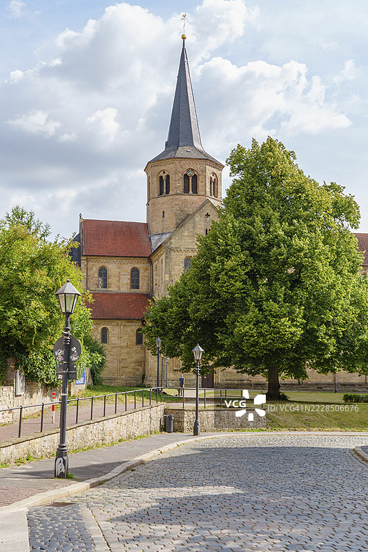 教堂前有陡峭的塔楼和绿色公园，蓝天明亮，德国下萨克森州希尔德斯海姆图片素材