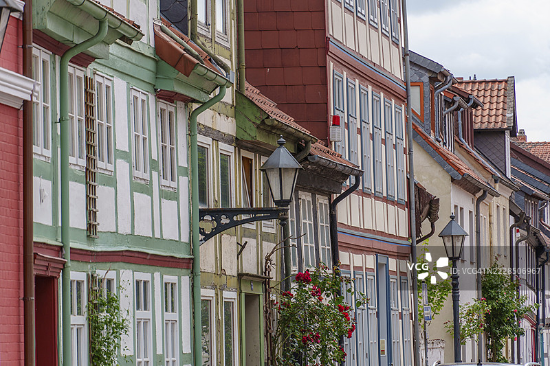 德国下萨克森州希尔德斯海姆一条古老街道上的五彩斑斓的半木结构房屋,街道上有灯笼和鲜花。图片素材