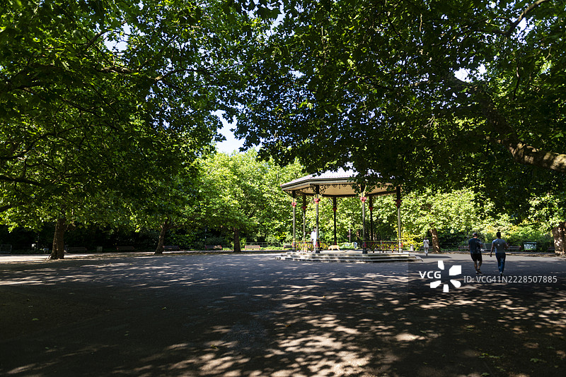 一个传统的乐队演奏亭静静地矗立在巴特西公园成熟的树木之间，环境宁静。图片素材