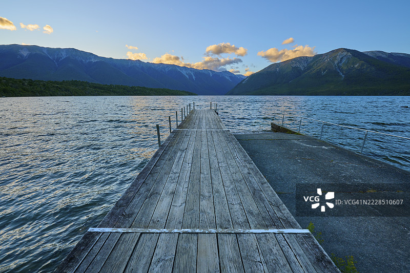 黄昏时分，湖边的木栈道与山脉、云彩，夏季，新西兰南岛塔斯曼地区圣阿尔诺德的罗托伊蒂湖图片素材