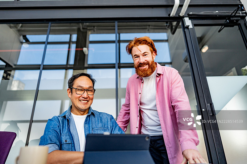 同事们在办公室交谈并使用数字平板电脑图片素材