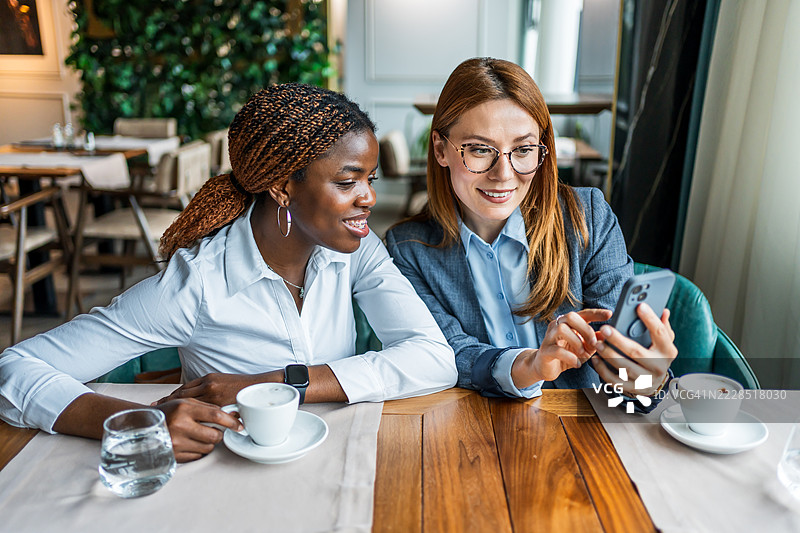 女商人在餐厅进行非正式会议并使用智能手机图片素材