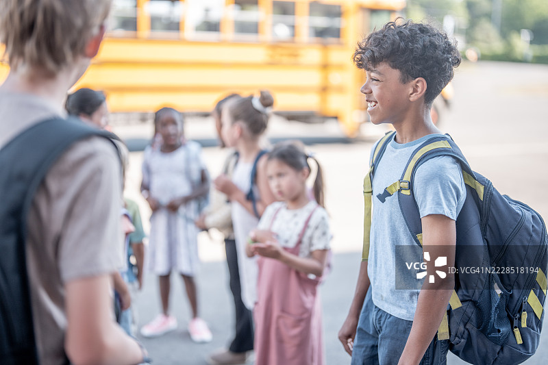 一群学校孩子在户外靠近校车微笑图片素材