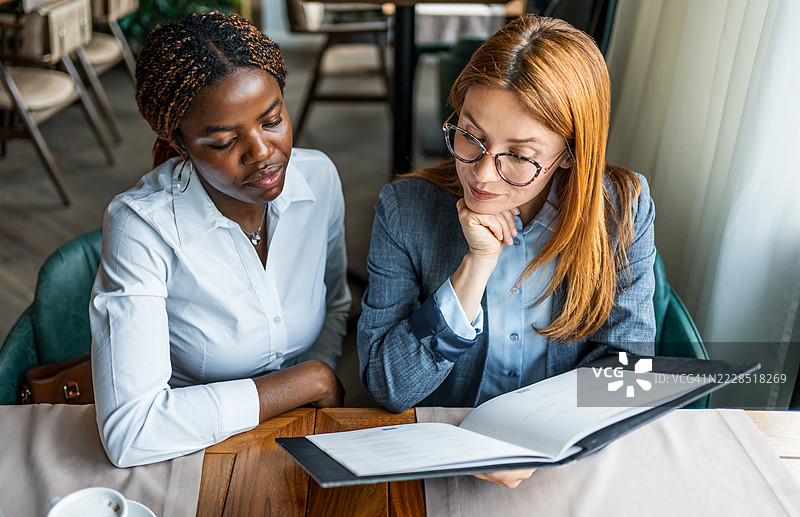 女商人在餐厅一起阅读文件图片素材