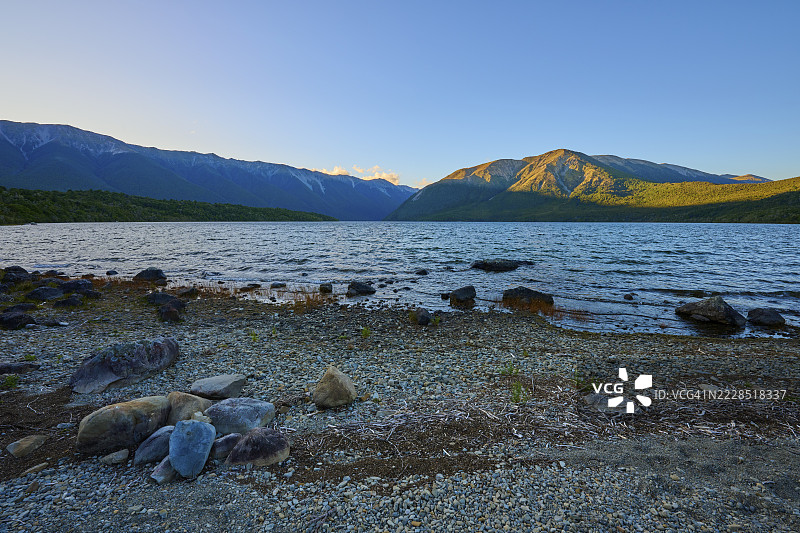 日出时分，夏季，罗托伊蒂湖，圣阿诺德，塔斯曼地区，新西兰南岛的石滩与山脉图片素材