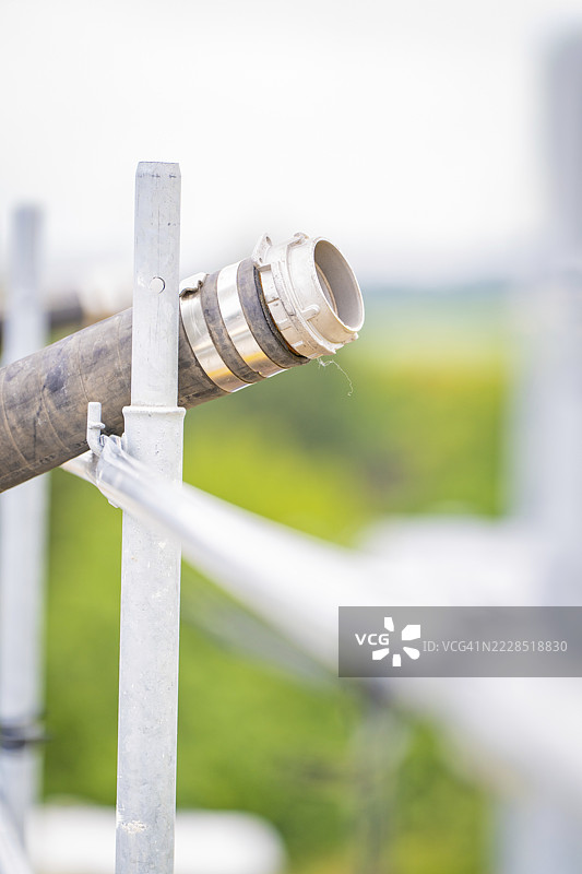 模糊的绿色背景下的金属管道及其安装，屋顶绿化，房屋建设，气候中性图片素材
