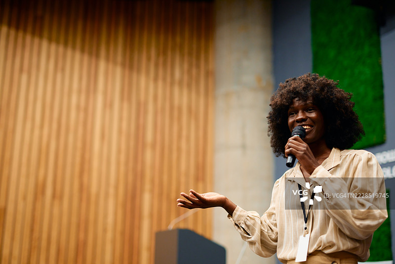 年轻女性手持麦克风发表演讲图片素材