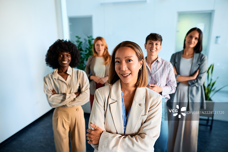五位微笑的女商人在办公室交叉双臂图片素材