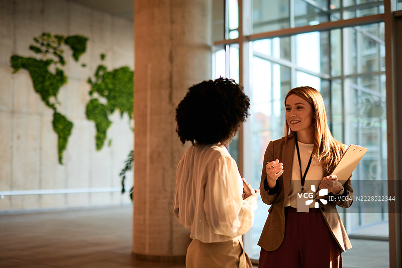 商务女性在现代办公大楼内开会讨论图片素材