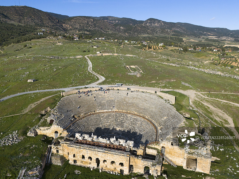 古老剧院的全景，坐落在广阔的绿色景观中，圆形剧场，鸟瞰图，希拉波利斯，帕穆卡莱，德尼兹利，安纳托利亚，土耳其图片素材