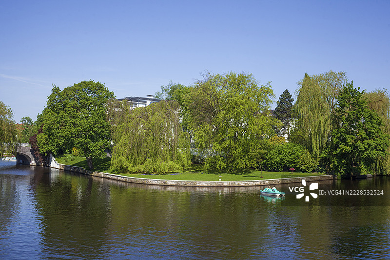 春天，汉堡冬胡德区外阿尔斯特湖侧湾的朗格扎格，船只、树木和高档住宅建筑。图片素材