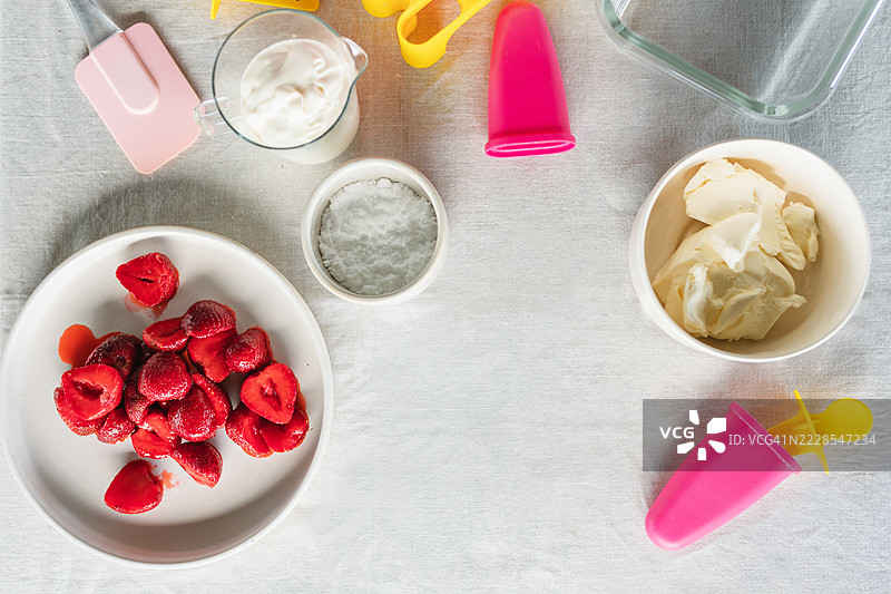 自制冰淇淋的原料和工具的俯视图，包含草莓、奶酪和奶油图片素材