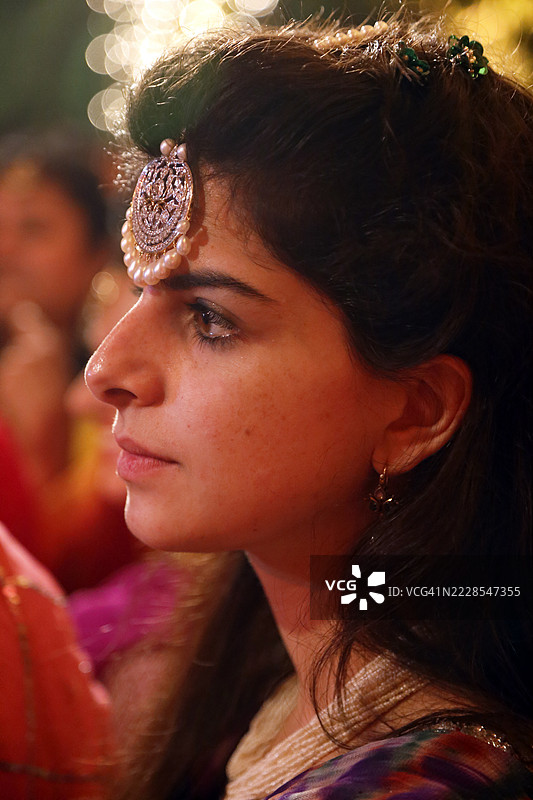 侧面特写，一位女性额头上佩戴着传统的蒂卡首饰。图片素材