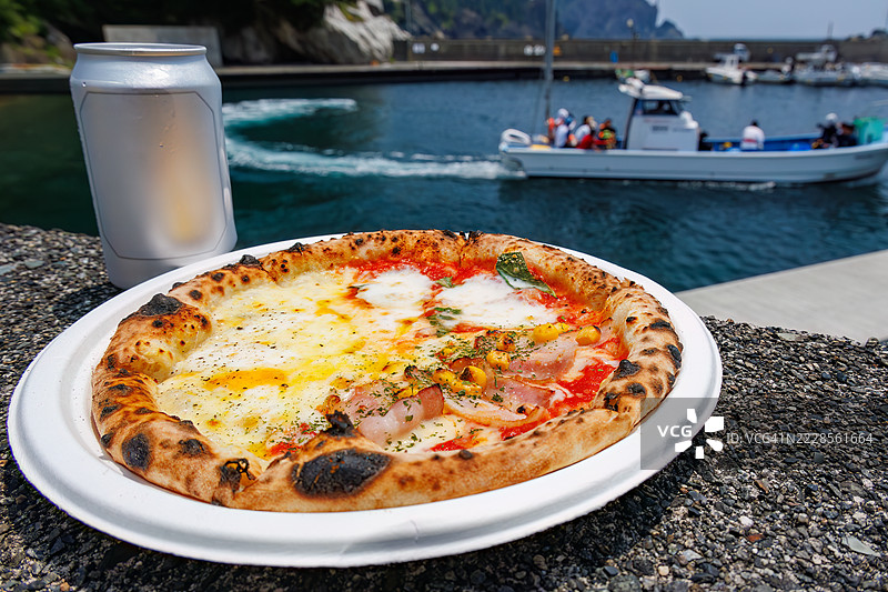 三种混合披萨，背景中可以看到希里佐海滩渡轮。图片素材