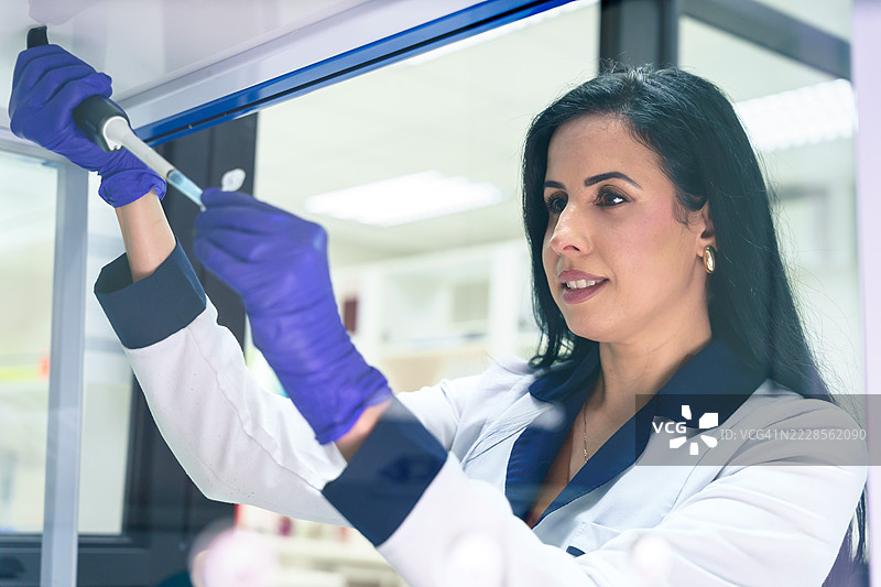 拉丁美洲科学家在实验室使用微量移液器工作图片素材