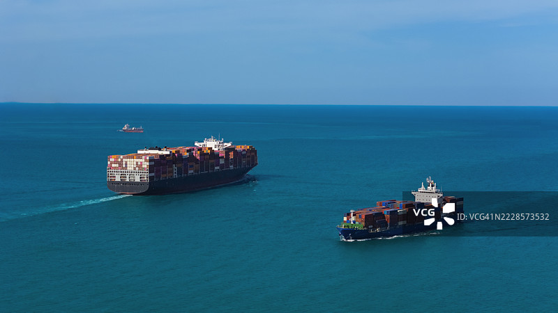 海上俯瞰两艘满载集装箱的货船，适用于商业物流、进出口、航运或货物运输。图片素材