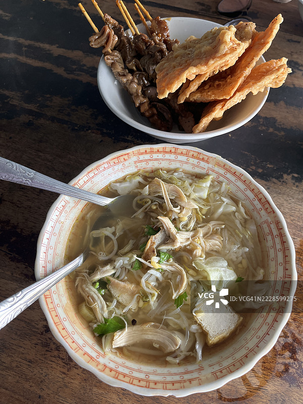 印尼传统鸡汤（Soto Ayam）配沙爹和天贝脆片图片素材