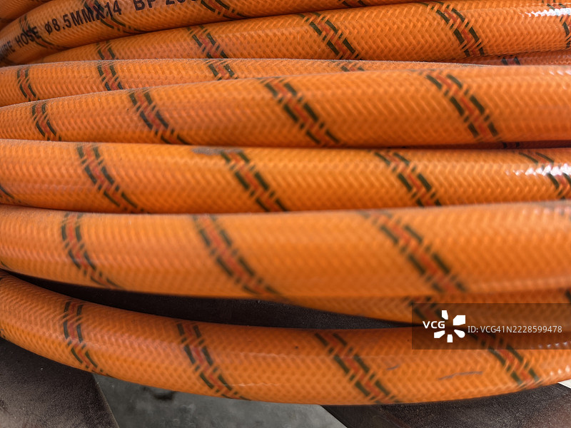 橙色编织PVC软管特写，带有条纹图案图片素材