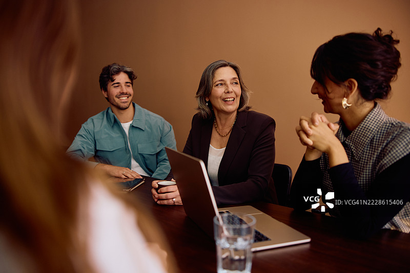 一群微笑的商业同事参与创意团队会议讨论图片素材