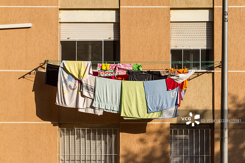 邻居窗户之间晾晒的衣物图片素材