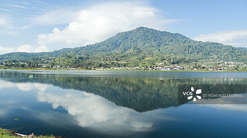 巴厘岛贝杜古尔潘查萨里村的布扬湖上塔帕克山的倒影图片素材