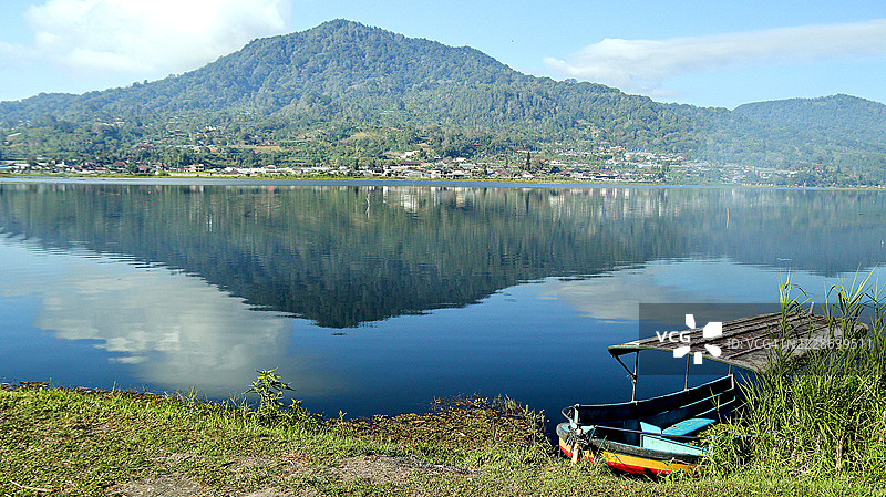 巴厘岛贝杜古尔潘查萨里村布扬湖上塔帕克山和莱松山的倒影图片素材