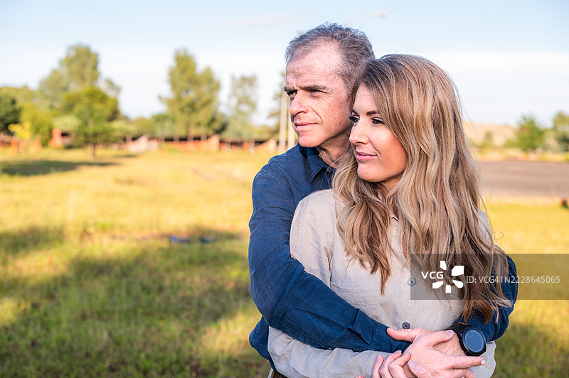 阳光下在风景如画的户外田野中相拥的恩爱情侣图片素材