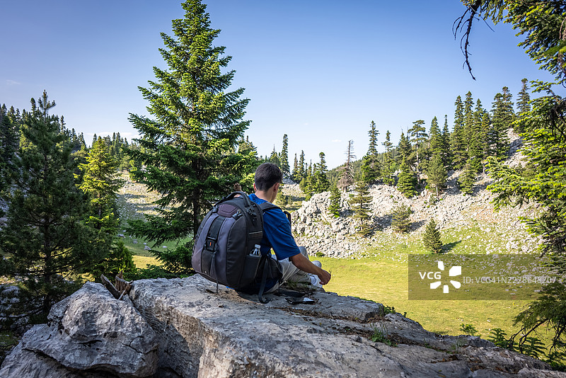 一个青少年在山中的森林里漫步图片素材