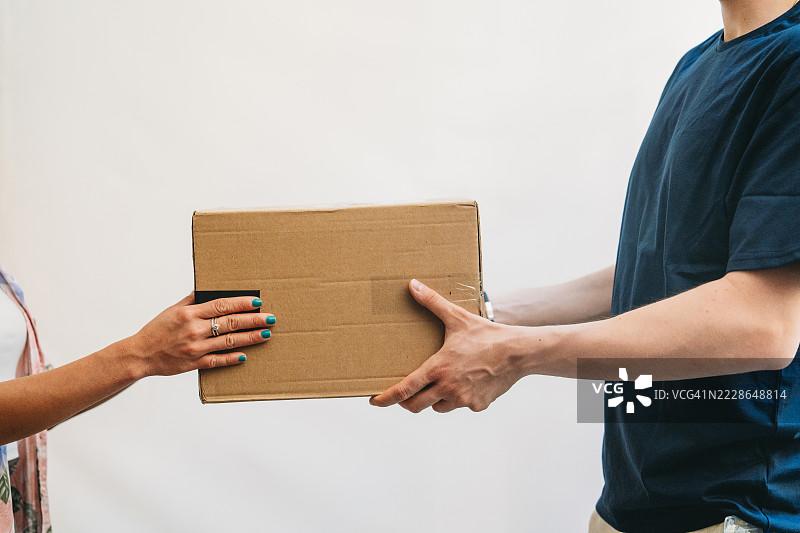 手交接纸箱包裹进行递送图片素材