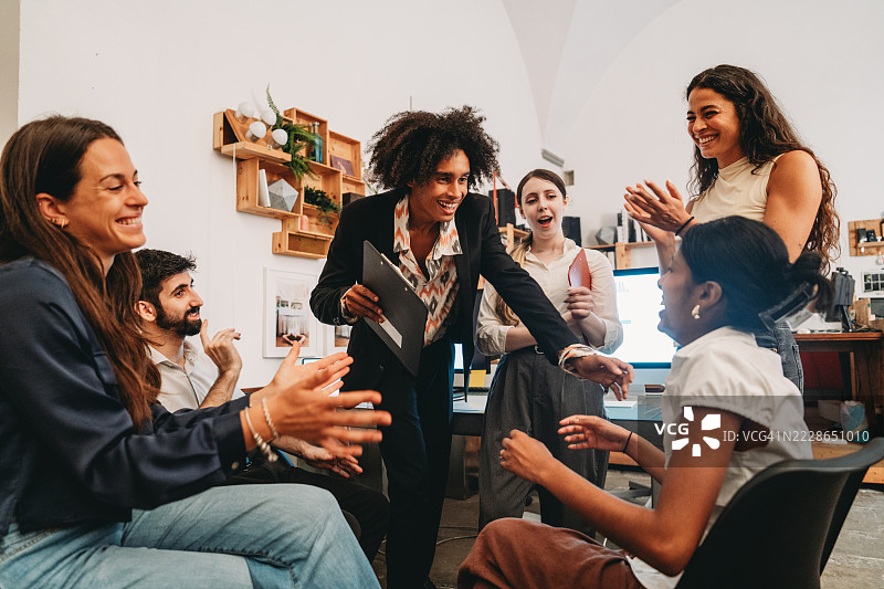 创意团队在办公室祝贺同事成功演讲图片素材