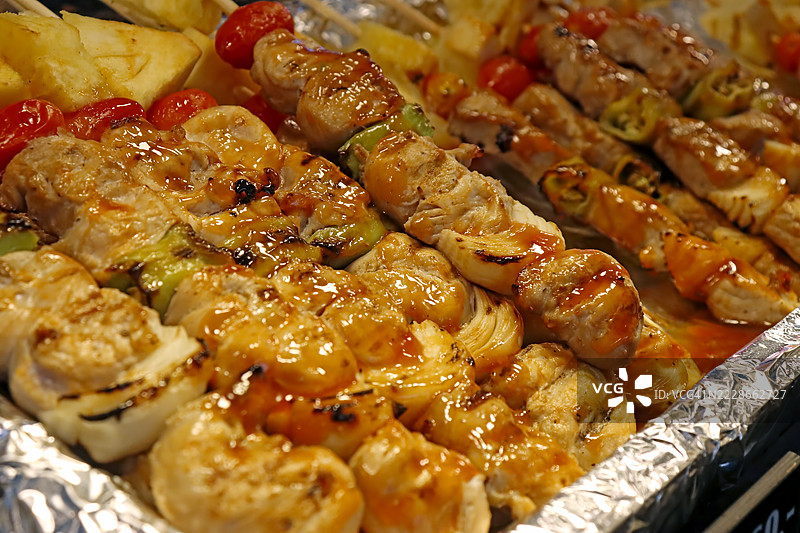 烧烤盛宴：串烧肉类和番茄的集合图片素材