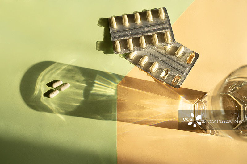 橙色和绿色背景上的胶囊和泡罩，泡罩内含胶囊图片素材