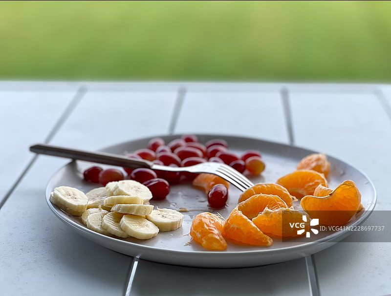 家园桌子上盛放着水果沙拉，旁边有一把叉子图片素材