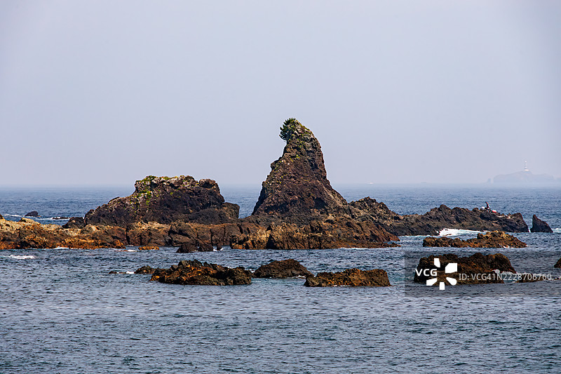 从公交车窗外看到的风景。一块因形状像哥斯拉而稍微有些名气的奇特岩石。图片素材