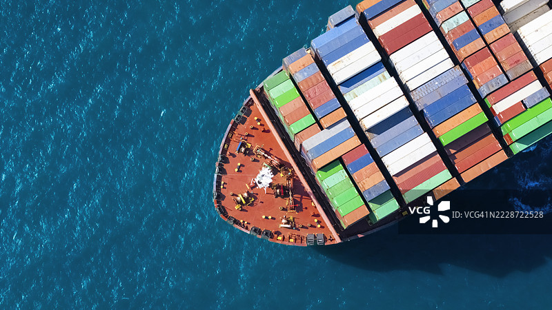 航拍视角的集装箱货船，满载集装箱，从商业港口的码头出发，适用于商业物流、进出口、运输或货运。图片素材