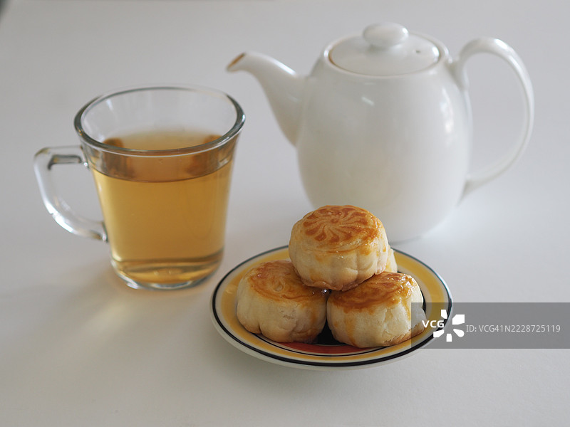 热茶甜点月饼，中华酥皮点心，咸蛋黄豆糕，泰式绿豆蛋糕，上面撒有黑芝麻，放在不锈钢格栅上。图片素材