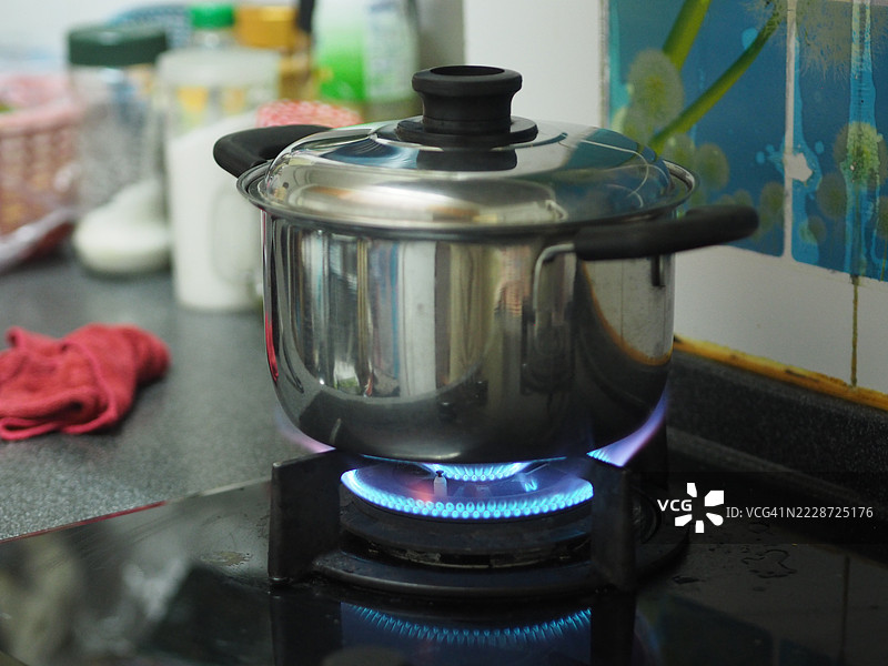 不锈钢锅在煤气炉上煮沸图片素材