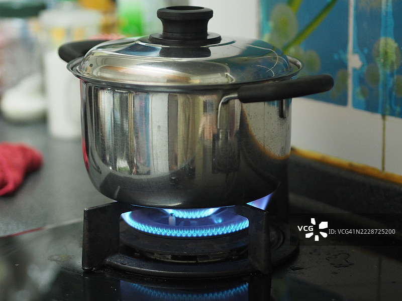 不锈钢锅在煤气炉上煮沸图片素材