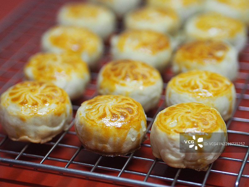 中式月饼、酥皮点心、豆沙咸蛋黄酥、泰式绿豆糕搭配黑芝麻，置于不锈钢网格上图片素材