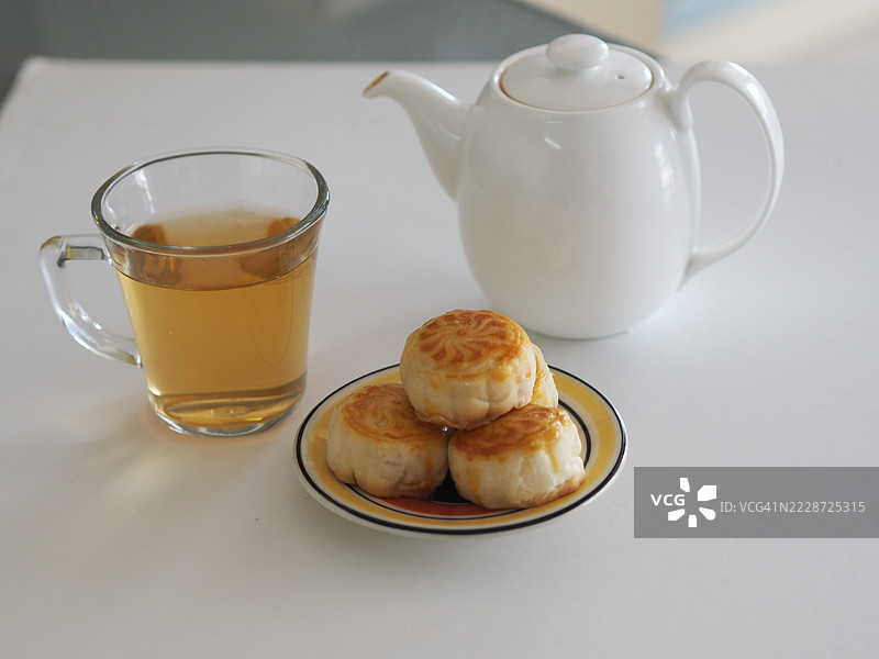 热茶甜点月饼，中华酥皮，咸蛋黄豆糕，泰式绿豆蛋糕，上面撒有黑芝麻，放在不锈钢格栅上。图片素材