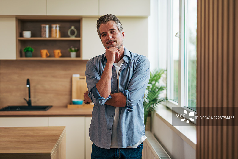 沉思的成熟男性在现代厨房中沉思图片素材