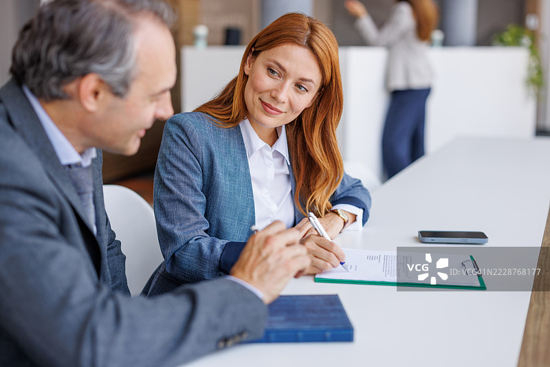 女商人在现代办公室与男商人签署合同图片素材